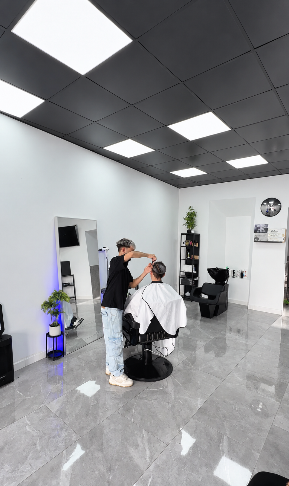 Barbero cortando el pelo en su local